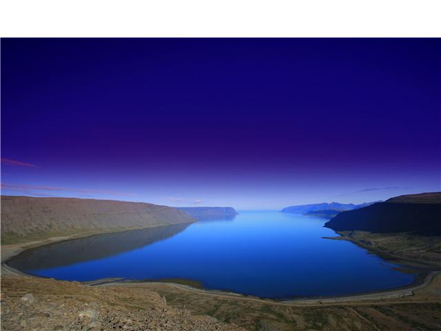 The Westfjords (Icelandic: Vestfirðir, ISO 3166-2:IS: IS-4) is a peninsula in northwestern Iceland. It is connected to the rest of Iceland by a 7 km wide isthmus between Gilsfjörður and Bitrufjörður. The Westfjords are very mountainous; the coastline is heavily indented by dozens of fjords surrounded by steep hills. The cliffs at Látrabjarg comprise the longest bird cliff in the northern Atlantic Ocean and are at the westernmost region of Iceland. The Drangajökull glacier is located in the far north of the peninsula and is the fifth largest of the country, but the only glacier of the region. The lack of flat lowlands in the area makes it unsuitable for agriculture, but good natural harbors in many of the fjords and closeness to fishing areas are vital for the local economy. The Westfjords is sparsely populated; the total population in 2007 was 7,380. The capital, (and largest town) is Ísafjörður (pop. ~ 3000), which serves as a center for commerce, administration and transportation in the region.